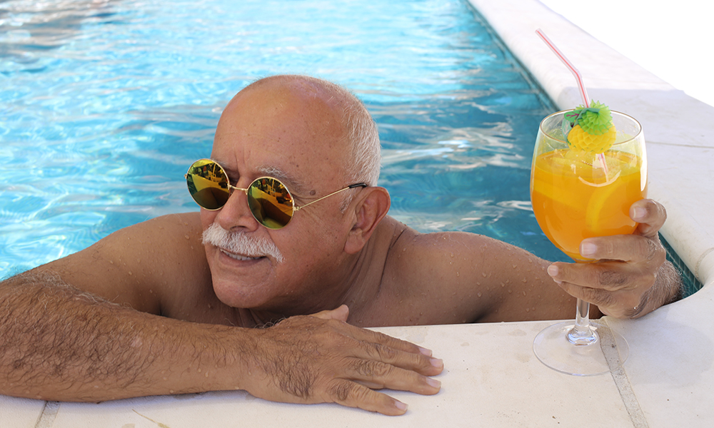 bald,senior,man,with,mustache,and,sunglasses,in,hotel,swimming