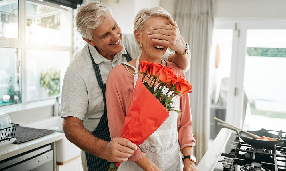 senior,couple,,covering,eyes,and,flowers,surprise,as,man,give