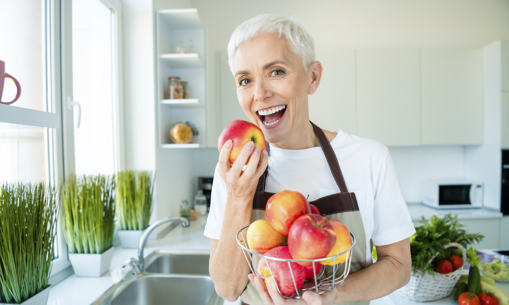 elderly,woman,enjoying,healthy,apples,in,bright,kitchen,,showcasing,cheerful