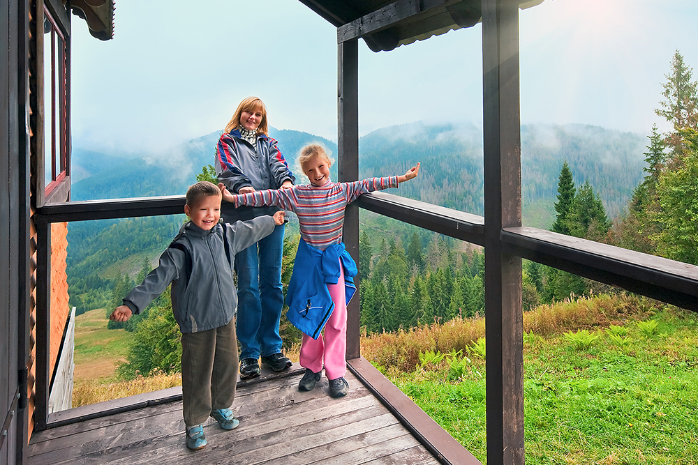 family,on,wooden,cottage,porch,on,mountain,hill,top,and