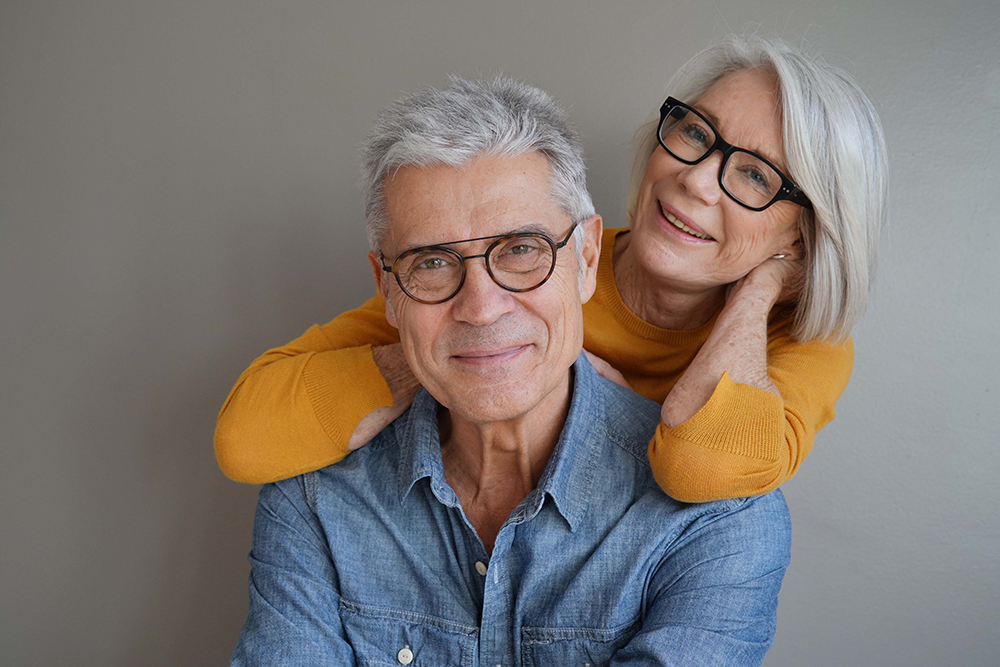 portrait,of,relaxed,fun,senior,couple,wearing,glasses,on,background