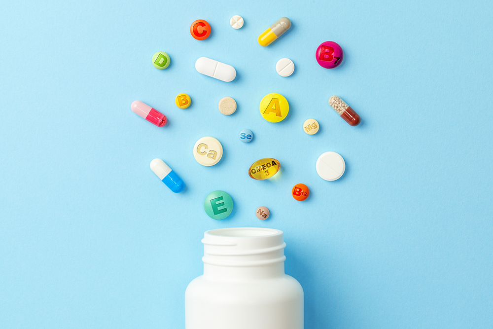 vitamin,tablets.,bottle,with,colored,pills,on,blue,background.,multivitamins.