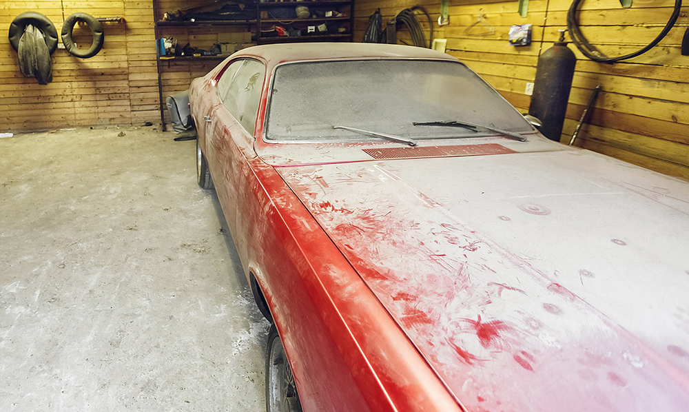 view,of,old,car,in,garage,with,dusty,hood,dirty