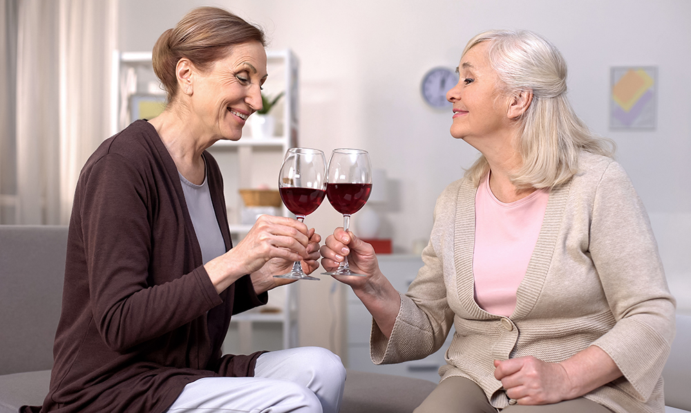 mature,female,friends,clinking,red,wine,glasses,enjoying,peaceful,rest