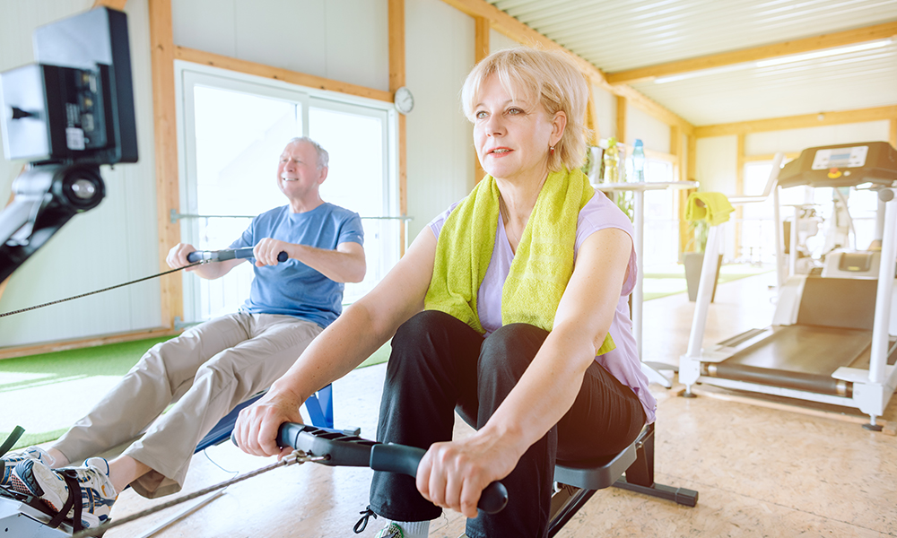 senior,couple,in,the,gym,on,a,rowing,machine,exercising