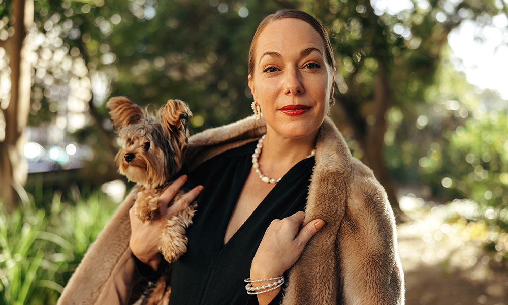 elegant,woman,looking,at,the,camera,while,holding,her,puppy