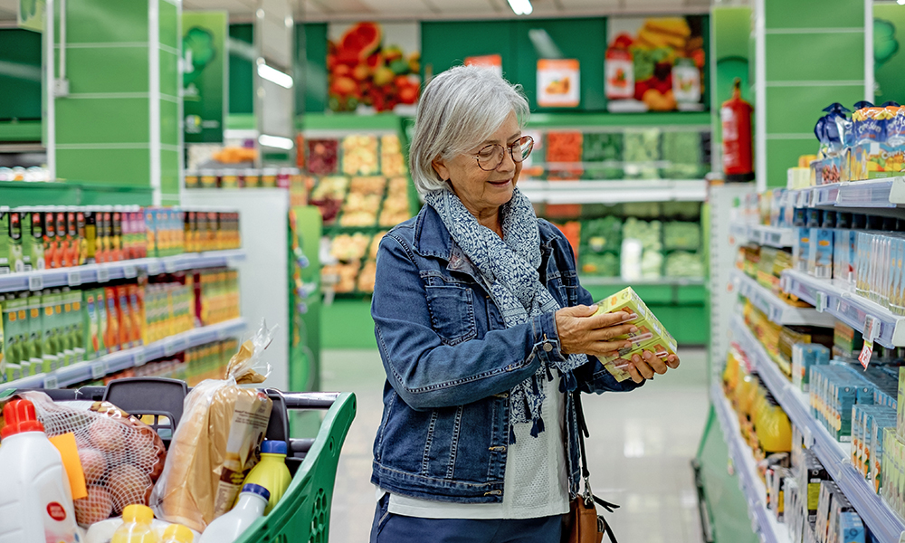 senior,smiling,woman,with,eyeglasses,pushing,a,shopping,cart,in