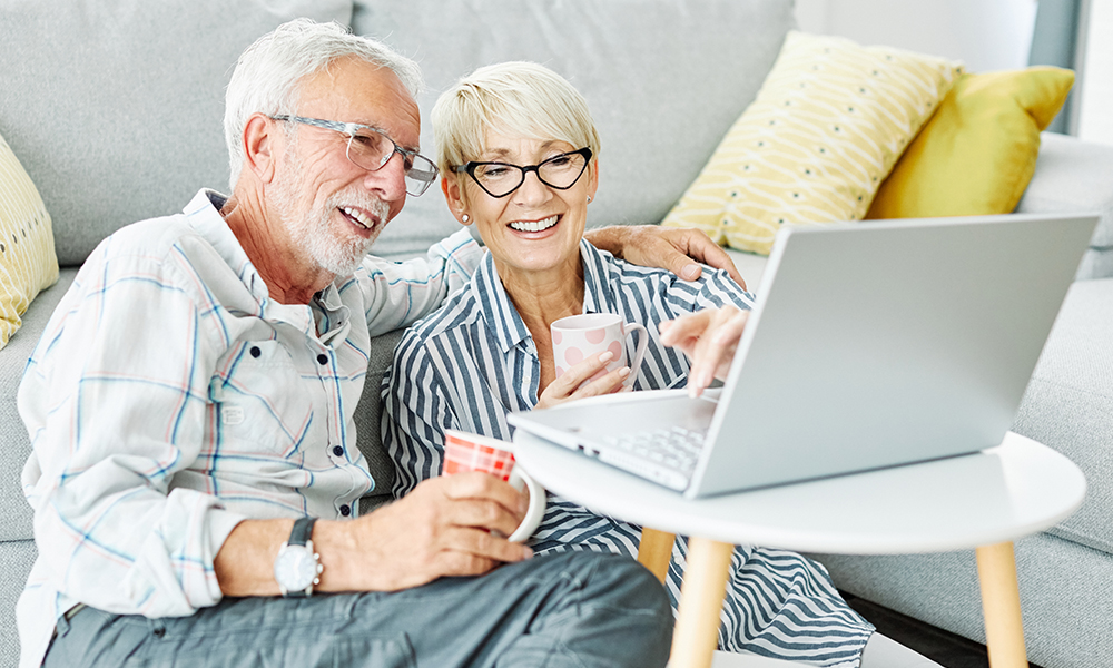 portrait,of,a,happy,smiling,elderly,senior,couple,using,laptop