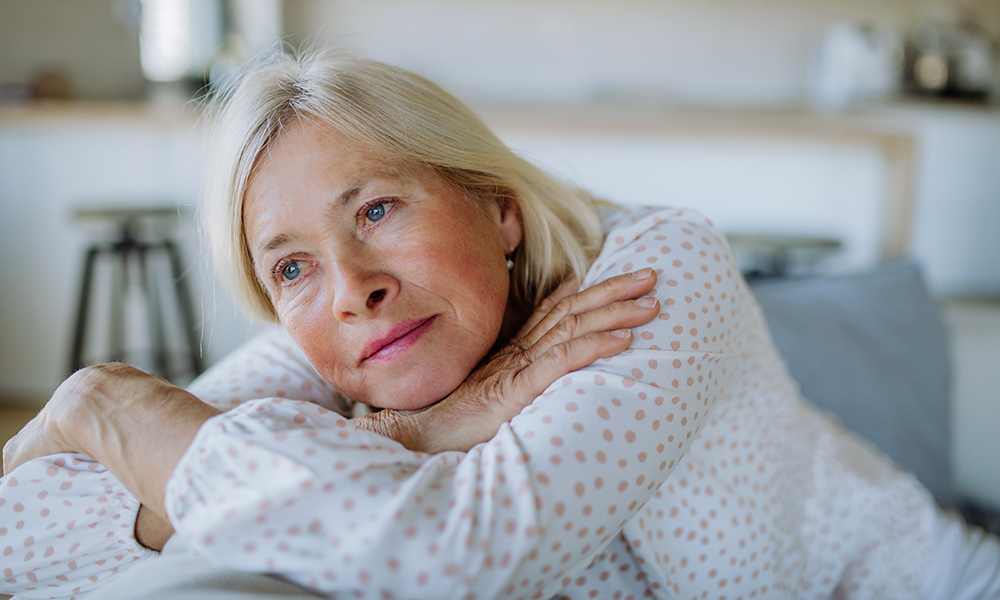 portrait,of,sad,attractive,senior,woman,sitting,on,a,sofa