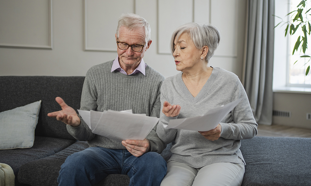 sad,tired,disappointed,middle,aged,senior,couple,sit,with,paper