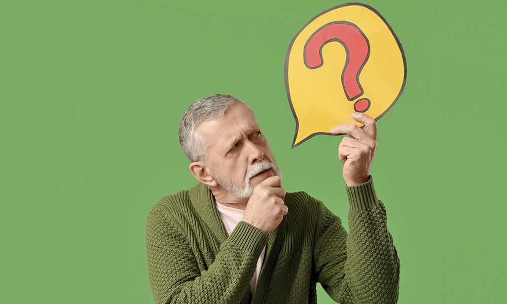 thoughtful,senior,man,holding,speech,bubble,with,question,mark,on