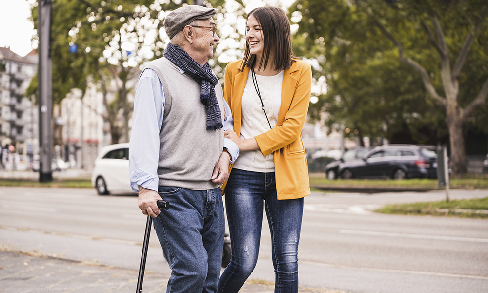 adult,granddaughter,assisting,her,grandfather,strolling,with,walking,stick