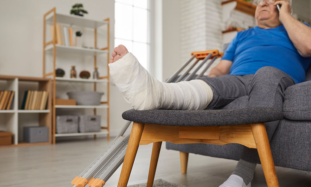 senior,man,with,broken,leg,in,gypsum,plaster,cast,sitting