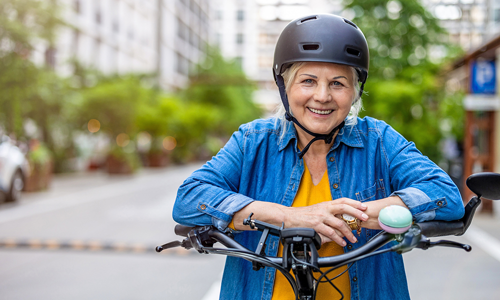 portrait,of,senior,woman,wearing,helmet,while,riding,bicycle,in