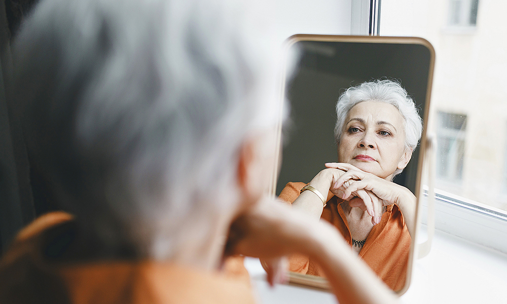 senior,elderly,female,with,gray,hair,and,wrinkles,looking,in