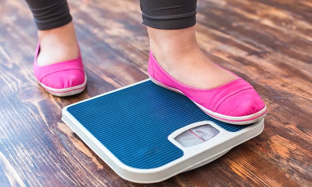 chubby,woman,sport,at,home,standing,on,scales,checking,weight