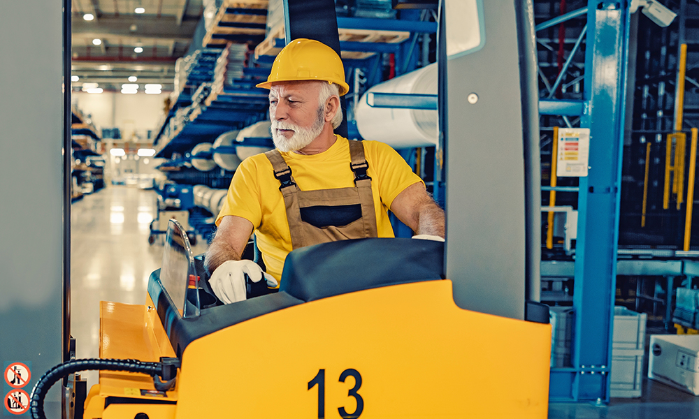 senior,worker,driving,electric,forklift,at,workplace.transport,and,processing,of