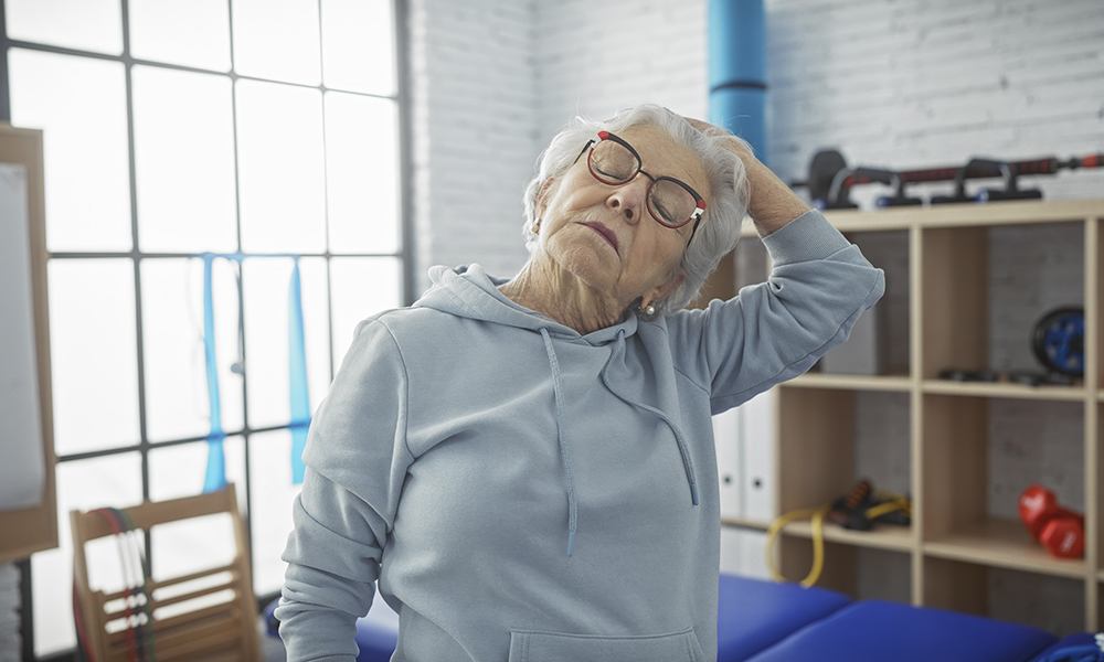 a,senior,woman,stretching,her,neck,in,a,physiotherapy,clinic,