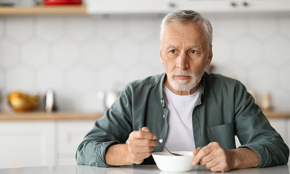 retirement,loneliness.,sad,senior,man,eating,alone,in,kitchen,interior,
