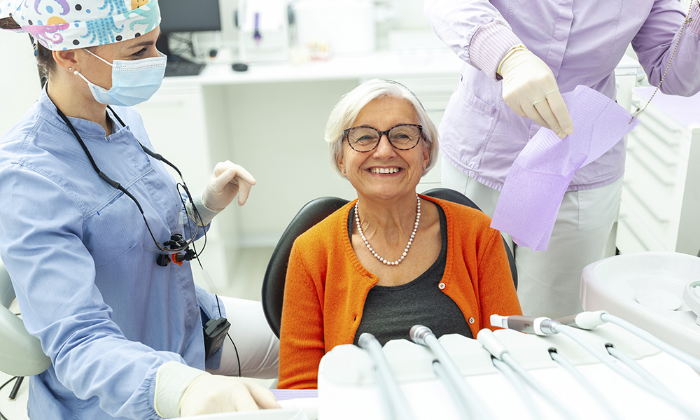 happy,elderly,woman,undergoing,dental,examination,by,two,dentists,in