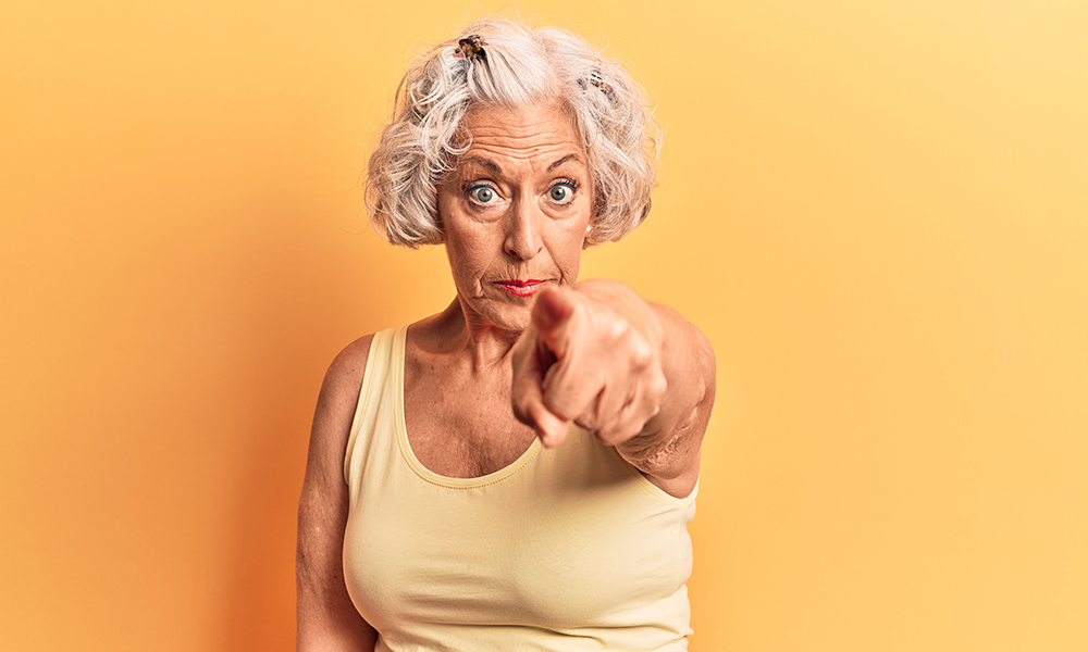 senior,grey haired,woman,wearing,casual,clothes,pointing,displeased,and,frustrated