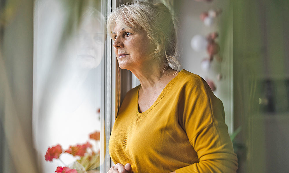 worried,elderly,woman,looking,in,window