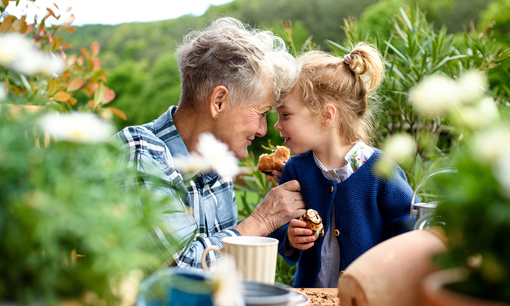 senior,grandmother,with,small,granddaughter,gardening,on,balcony,in,summer,