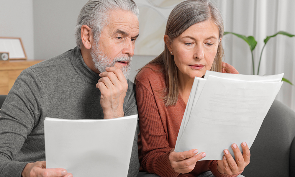 elderly,couple,with,papers,discussing,pension,plan,in,room