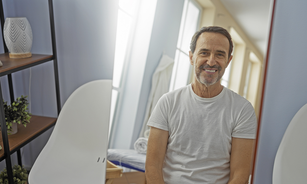 hispanic,man,in,a,spa,room,smiles,at,his,reflection,