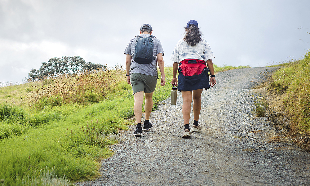 couple,walking,uphill,under,a,stormy,sky.,long,bay,coastal