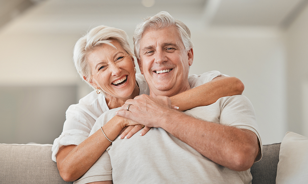 happy,senior,couple,,portrait,and,hug,on,living,room,sofa