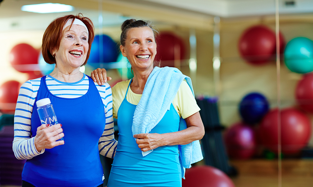 cheerful,grandmas,in,activewear,looking,at,something,curious,in,gym