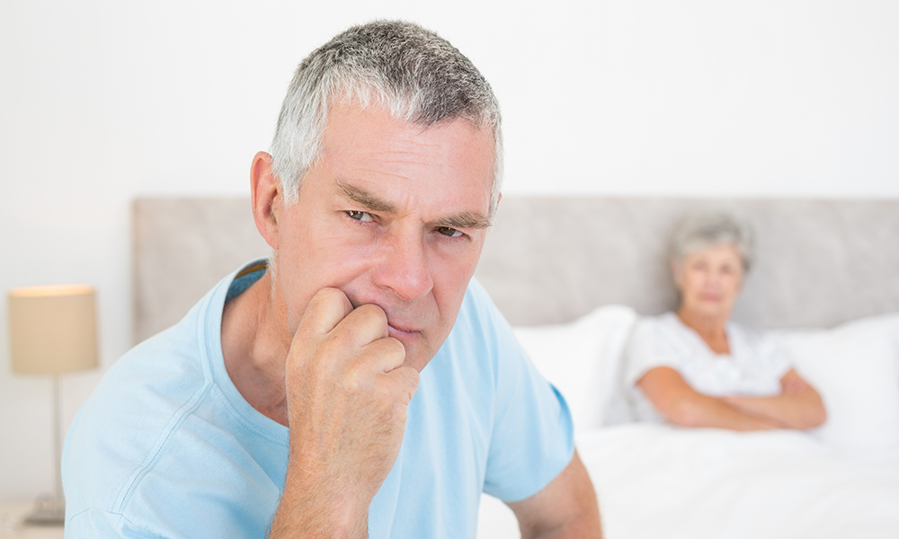 thoughtful,senior,man,looking,away,with,woman,in,background,at