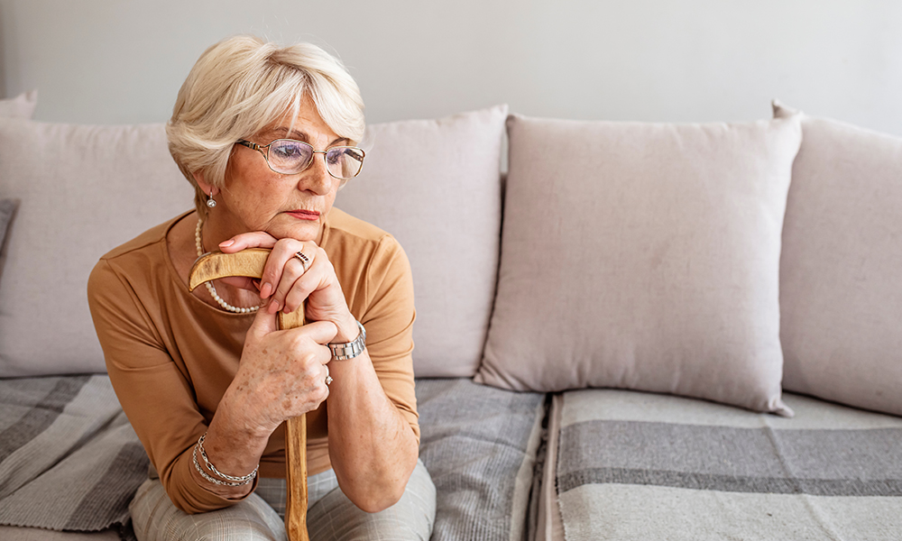 pensive,mature,woman,holding,wooden,cane,,thinking,about,problems,,looking