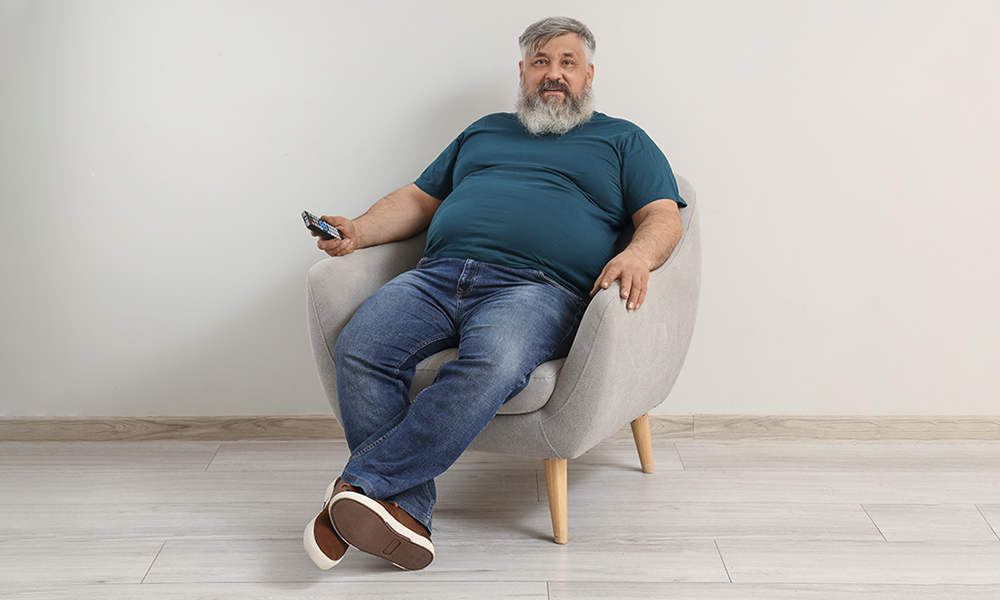 mature,man,watching,tv,in,armchair,near,light,wall