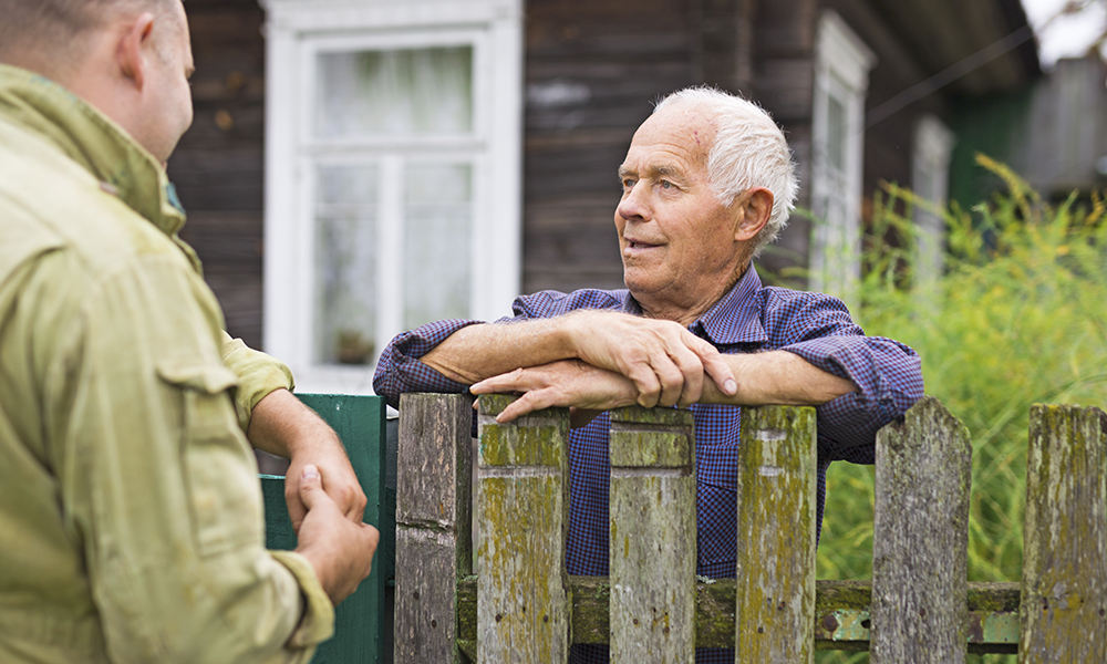 elderly,man,discussing,with,neighbour,beside,house