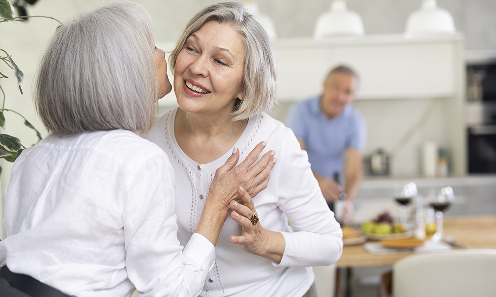 two,elderly,women,friends,hugging,when,meeting,in,kitchen